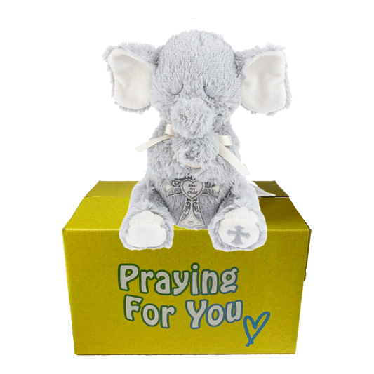 Enzo the gray plush elephant praying toy on a yellow box with 'Praying For You' text.  Christian baby keepsake at sendapraynow.com