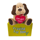 Baxter Prayer Companion plush dog holding embroidered "Get Well Soon" heart sitting on yellow "praying for you" box